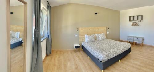 1 dormitorio con 1 cama y suelo de madera en The Globetrotter's Inn, en Ericeira