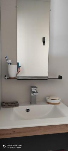 La salle de bains est pourvue d'un lavabo avec miroir et de toilettes. dans l'établissement Baia 1, à Drammont