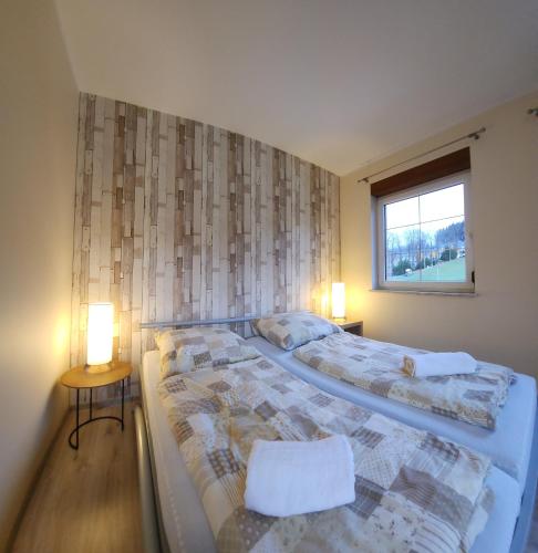 two beds in a room with two lamps and a window at Willa Sielanka in Karpacz