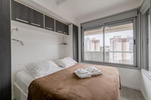 a bedroom with a bed with two towels on it at Trend NCG - Apartament 1602 in Porto Alegre