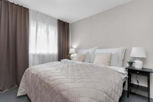 a white bedroom with a large bed and a window at Cheerful 3BR Down Town Newly Renovated in Reykjavík