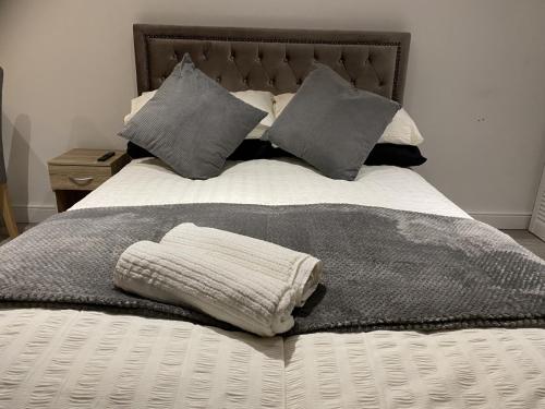 ein Bett mit einer Decke und Kissen darauf in der Unterkunft Modern Guest house with private entrance in Manchester