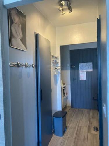 une chambre avec un couloir avec une porte bleue et une chambre avec une cuisine dans l'établissement studio agay a 2 pas des plages, à Saint-Raphaël