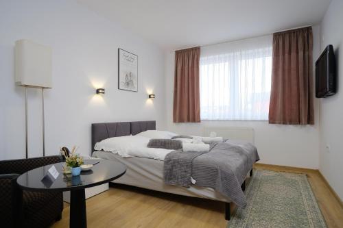 a hotel room with a bed and a table at Apartmani NAN in Visoko