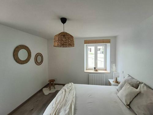 a white bedroom with a bed and a window at Superbe appartement neuf et cosy 77 m2 in Villers-le-Lac
