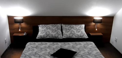 a bedroom with a bed with two pillows and two lamps at Willa Piasutno z klimatyzacją in Świętajno