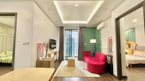 a living room with a red chair and a bed at LAD Apartment & Homestay Hải Phòng - Hoàng Huy Grand Tower in Hai Phong
