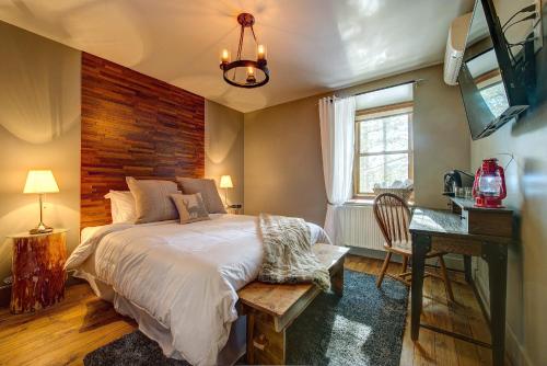 a bedroom with a bed with a wooden wall at Auberge le Cosy in La Conception
