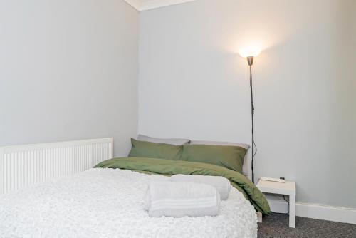 a white bedroom with a bed with towels on it at Shirley House 4, Guest House, Fully Equipped Kitchen with Fridge, Washer, Dryer, Self Catering, Self Check in, Great for Contractors, 5 min to BAT, 20 min to Fawley Refinery, close to Southampton Central, Ideal for Longer Stays in Southampton