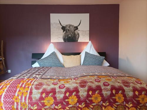 ein Schlafzimmer mit einem Bett mit einem Stier an der Wand in der Unterkunft Am Sommerberg in Unterkirnach