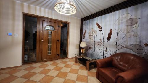 a living room with a leather chair and a door at Willa Sielanka in Karpacz