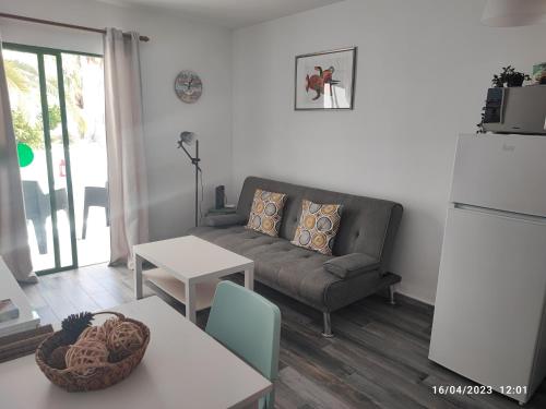 ein Wohnzimmer mit einem Sofa und einem Tisch in der Unterkunft Precioso y céntrico apartamento in Costa Teguise