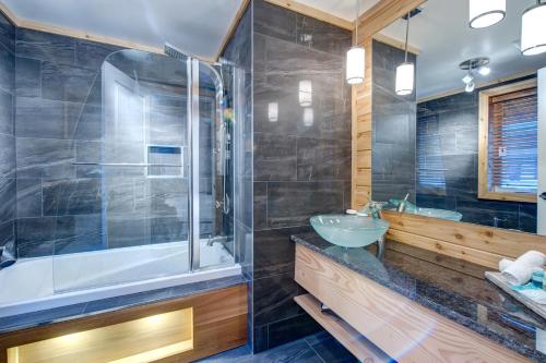 a bathroom with a tub and a sink and a shower at Auberge le Cosy in La Conception