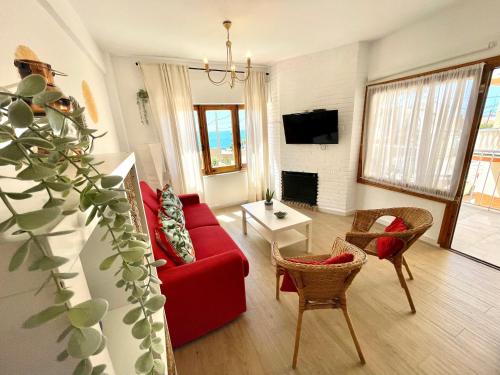 - un salon avec un canapé et des fauteuils rouges dans l'établissement GATU Villa Cielo y Mar junto la playa, terraza , wifi y vista al mar, à El Puerto de Santa María