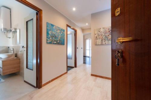 einen Flur eines Badezimmers mit einer Tür und einem Waschbecken in der Unterkunft Casa Dalia Terrazze Relax e WiFi in Santa Margherita Ligure