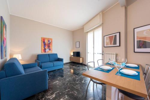 ein Wohnzimmer mit einem blauen Sofa und einem Tisch in der Unterkunft Casa Dalia Terrazze Relax e WiFi in Santa Margherita Ligure