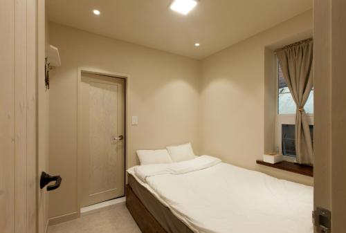 a small bedroom with a bed and a window at Jeonju Hanok Little Prince in Jeonju