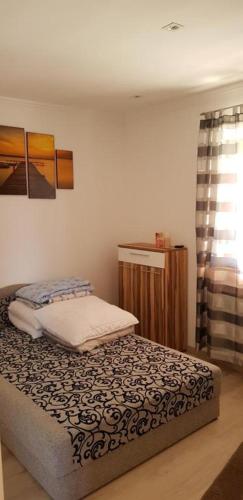 a small bedroom with a bed and a window at Rajmund vendeghaz in Balatonkeresztúr