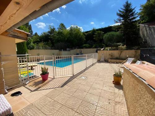 une terrasse avec une clôture et une piscine dans l'établissement Maison de famille (piscine, jacuzzi et sauna), à Quillan