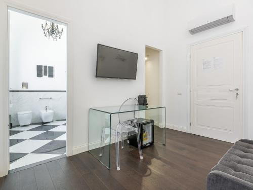 a living room with a glass table and a tv at PLEY Cagliari Boutique Suites in Cagliari