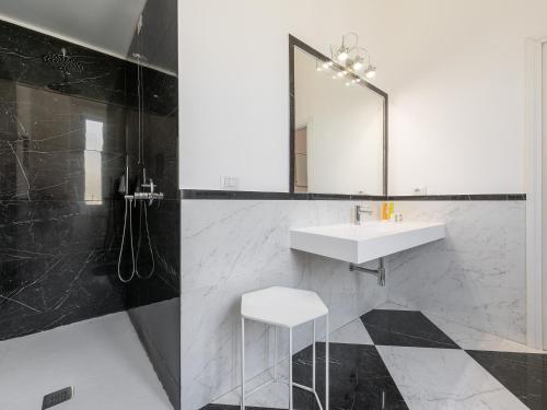 a bathroom with a sink and a mirror and a stool at PLEY Cagliari Boutique Suites in Cagliari