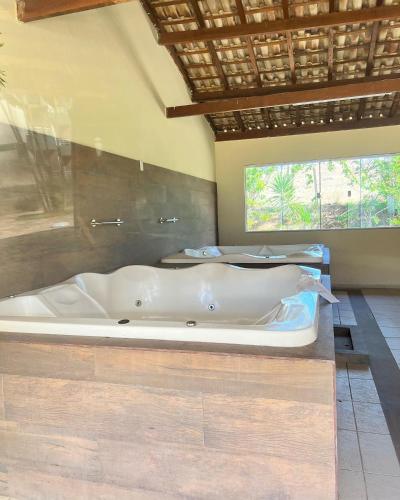 a bath tub in a room with two beds at Flat no Aldeia das Águas Park Resort in Barra do Piraí