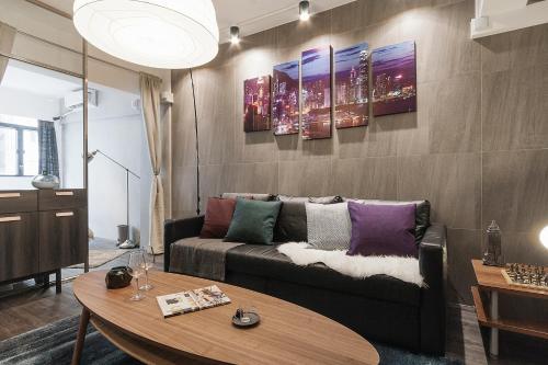 a living room with a couch and a table at L'Escale - by Maeva in Hong Kong