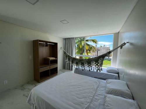 a bedroom with a bed and a window at Casa Maragogi, Piscina, 4 Suítes, 100 Mts Praia in Maragogi