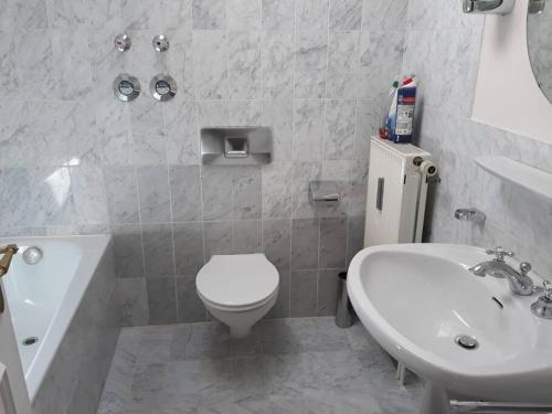a bathroom with a white toilet and a sink at Urlaub in der königlichen Villa in Berchtesgaden