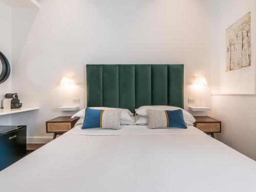 sypialnia z dużym łóżkiem z zielonym zagłówkiem w obiekcie PLEY Cagliari Boutique Suites w Cagliari