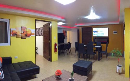 a room with a table and chairs and a television at White Sands Villas Maribago Lapu Lapu Cebu Tourist Area in Maribago
