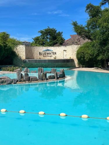 a swimming pool with blue water in a resort at White Sands Villas Maribago Lapu Lapu Cebu Tourist Area in Maribago