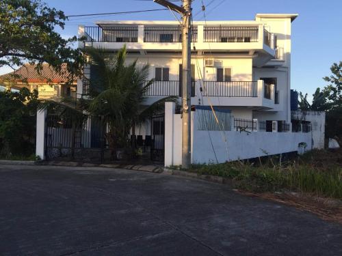 un edificio de apartamentos blanco con una calle delante en White Sands Villas Maribago Lapu Lapu Cebu Tourist Area, en Maribago