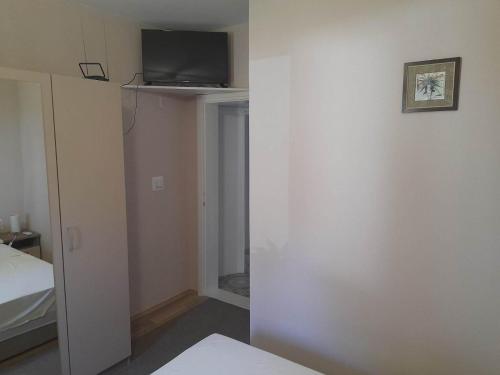 a room with a bed and a tv on a wall at Villa Wind Apartments in Drače