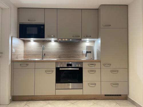 a kitchen with white cabinets and a stove top oven at Ferienwohnung Schwarzkollm in Hoyerswerda
