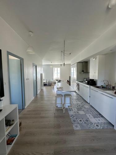 a large white kitchen with a table and chairs at Appartement Design I - Port du Rosmeur - Douarnenez in Douarnenez