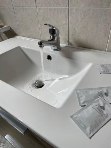 a white sink with water running from a faucet at La Rosa Blu in San Vito lo Capo