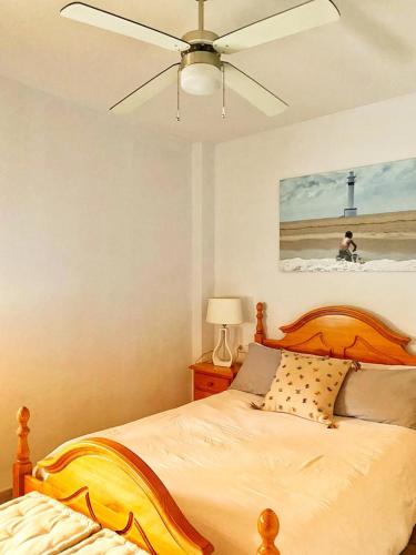 a bedroom with a bed with a ceiling fan at MANDARINA in Riumar