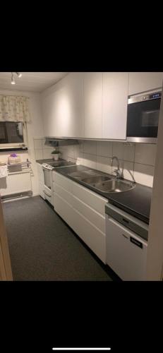a kitchen with a sink and a microwave at Charming room with big bed in Luleå