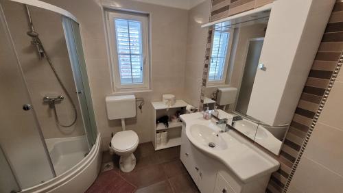 a bathroom with a sink and a toilet and a shower at Katy in Krk