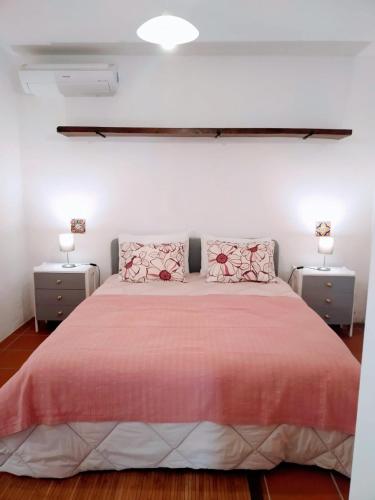 a bedroom with a large bed with two night stands at Moita Cottage in Moita