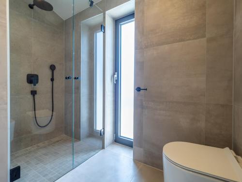 a bathroom with a toilet and a glass shower at Villa Greta in Risika