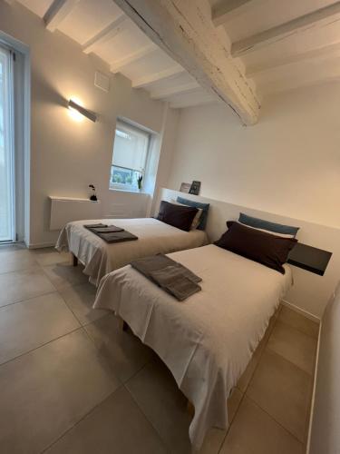 two beds in a room with white walls at CasaDea in Cremona