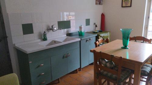 a kitchen with a sink and a table with a dining room at Il terrazzo dei nonni in Modica