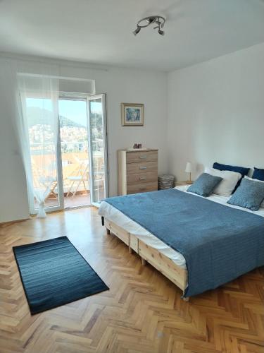 een slaapkamer met een groot bed met een blauwe deken bij Apartman Megi in Dubrovnik