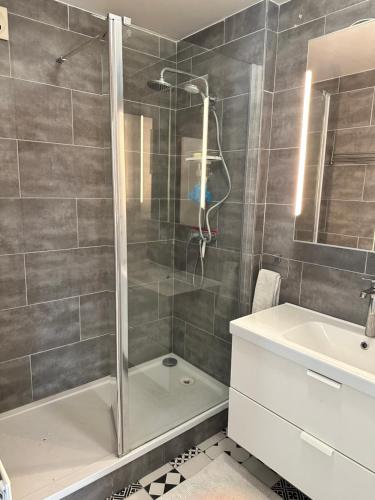 une salle de bain avec douche et lavabo dans l'établissement Appartement Lumineux Accor Arena Paris 13, à Paris