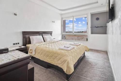 een slaapkamer met een groot bed en een raam bij Magnifique appartement en plein centre ville in Marrakesh