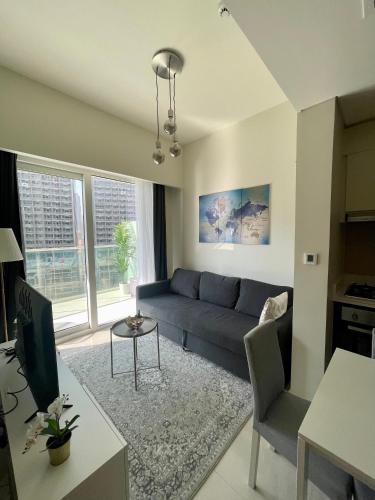 a living room with a blue couch and a table at New Reva Hotel Apartment next Burj Khalifa in Dubai