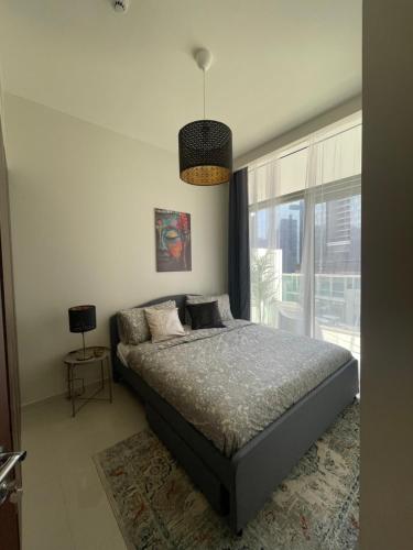 a bedroom with a bed and a large window at New Reva Hotel Apartment next Burj Khalifa in Dubai