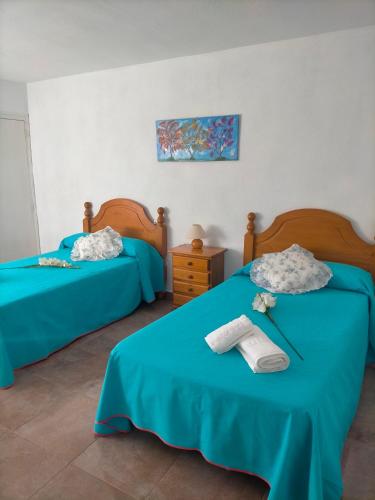 2 camas en una habitación con sábanas azules en Casa joselito, en Casas del Cerro